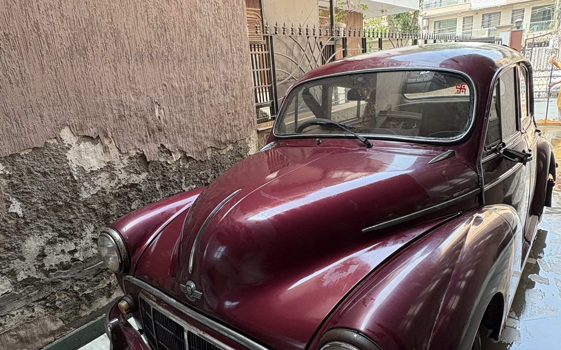 Maroon Morris Minor 1000 four-door saloon for sale in Gurgaon, photographed from the front three-quarter angle